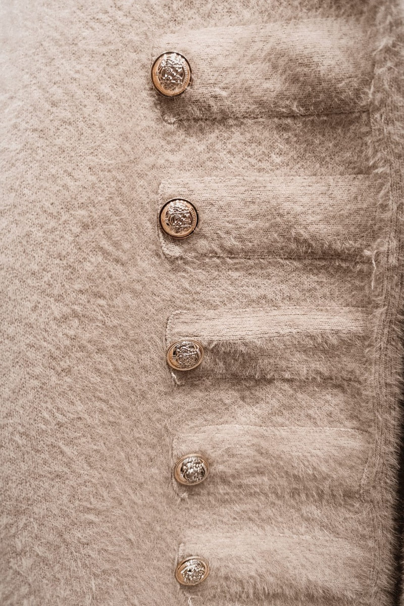 Veste courte duveteuse et texturée, dotée d'un col rond et de superbes boutons dorés disposés en double rangée